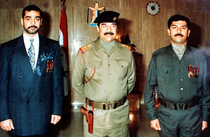 Former Iraqi President Saddam Hussein (C) flanked by his two late sons Uday (L) and Qusay on December 13, 1996 (photo credit: REUTERS/STRINGER MD/CRB)