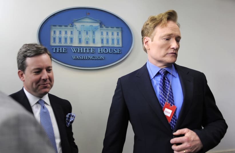 Late night television host Conan O'Brien (R) is escorted by Fox News correspondent Ed Henry in the James Brady Press Room as he tours the White House, in Washington, April 26, 2013. O'Brien will be hosting the White House Correspondents Associations' annual gala on Saturday. (photo credit: MIKE THEILER/REUTERS)