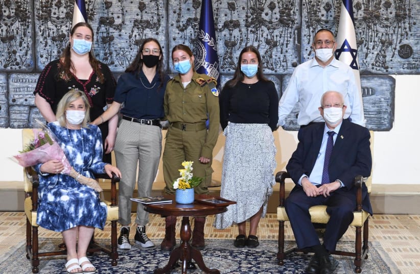 President Reuven Rivlin is seen hosting a lone soldier and her family at the President's Residence. (photo credit: MARK NEYMAN/GPO)