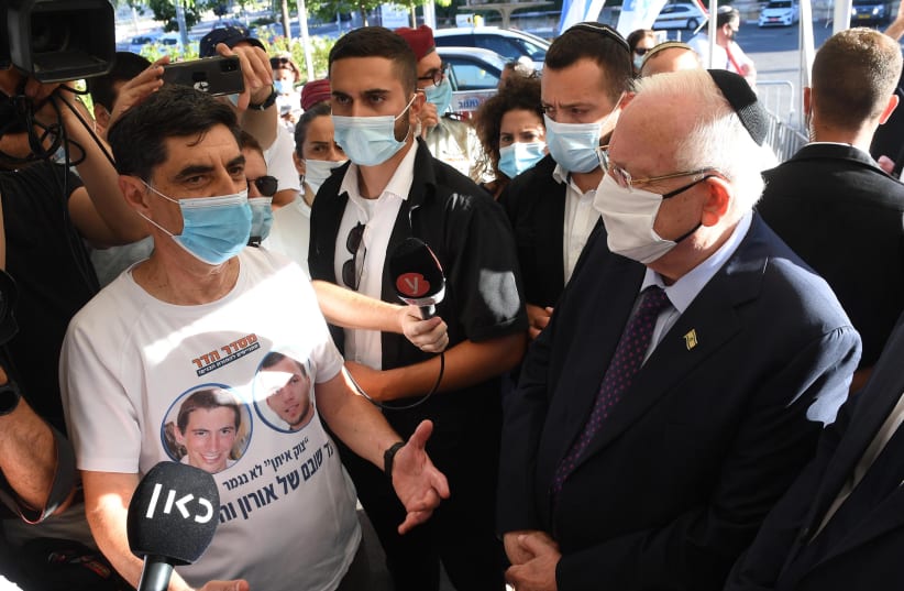 Prof. Simcha Goldin (L) with a shirt calling for the return of his son's remains to burial in Israel with President Reuven Rivlin (R)   (photo credit: MARK NEYMAN / GPO)