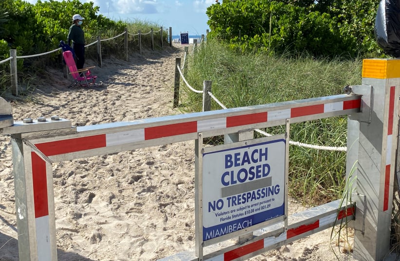 A sign informing about South Beach closure, to prevent the spread of the coronavirus disease (COVID-19), is seen ahead of the Fourth of July weekend, in Miami Beach, Florida, U.S., July 3, 2020 (photo credit: REUTERS/ELIZABETH FERIA)