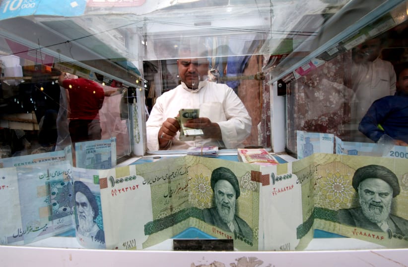 A man counts Iranian rials at a currency exchange shop before the start of the US sanctions on Tehran (photo credit: REUTERS/ESSAM AL-SUDANI)