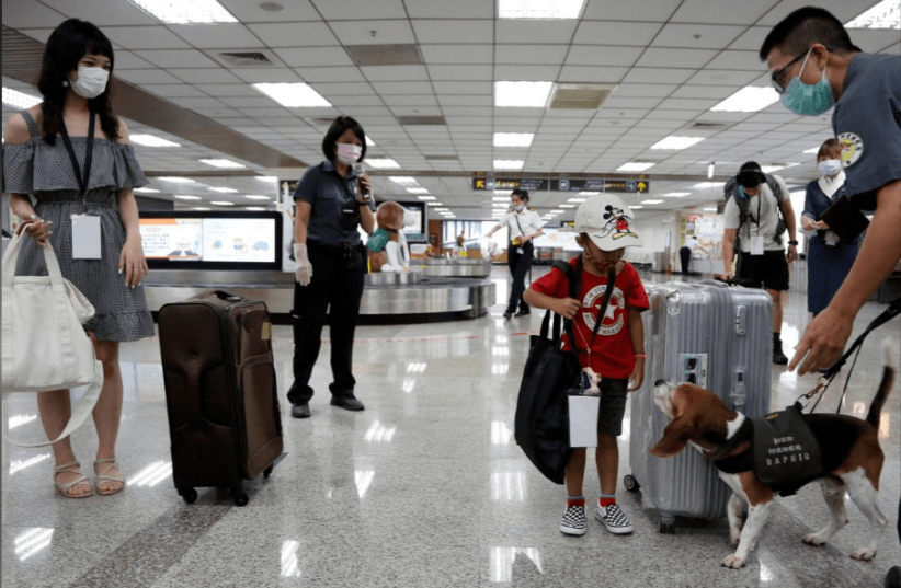 People who want to leave the island, but cannot due to coronavirus disease-related (COVID-19) travel restrictions, take part in a fake travel experience for tourists  in Taipei, Taiwan July 2, 2020. (photo credit: ANN WANG / REUTERS)