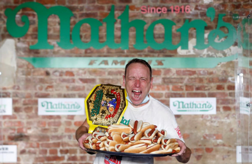 Joey Chestnut poses after winning the Nathan's Famous Fourth of July International Hot Dog Eating Contest with a world record 75 hot dogs consumed in Brooklyn, in New York City, U.S., July 4, 2020 (photo credit: ANDREW KELLY / REUTERS)