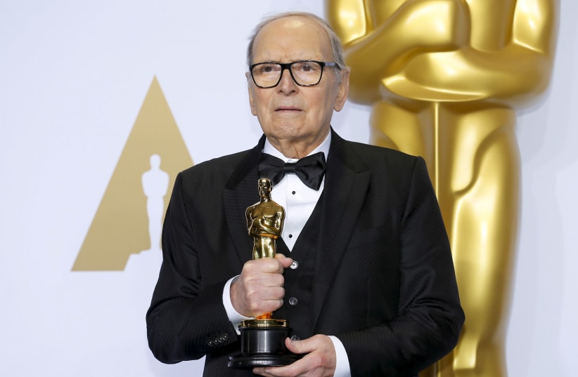 Italian composer Ennio Morricone poses with his Oscar for Best Original Score for "The Hateful Eight," during the 88th Academy Awards in Hollywood, California February 28, 2016 (photo credit: MIKE BLAKE/REUTERS)