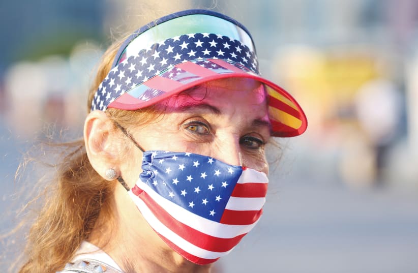 A WOMAN wears a patriotic mask at Gantry Plaza State Park in New York in honor of July 4th. (photo credit: CAITLIN OCHS/REUTERS)