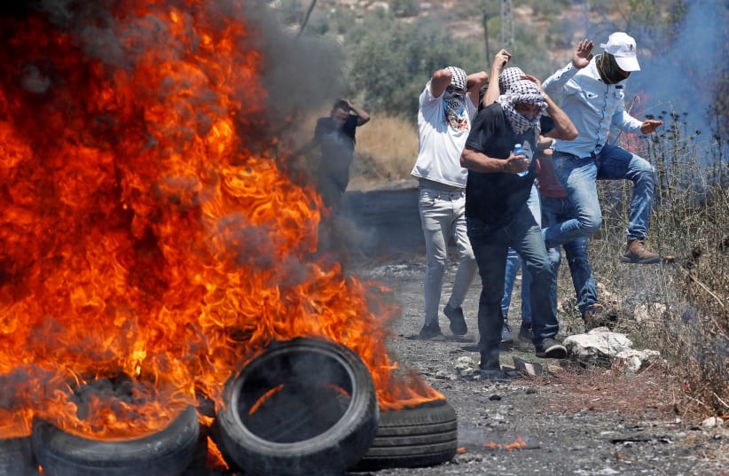 Palestinian demonstrators react to Israeli gunfire during a protest against Israel's plan to annex parts of the West Bank, in Kafr Qaddum near Nablus July 3, 2020. (photo credit: MOHAMAD TOROKMAN/REUTERS)
