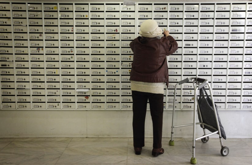 AN ELDERLY Russian immigrant checks her mail at the Diplomat Hotel in Jerusalem (photo credit: MIRIAM ALSTER/FLASH90)