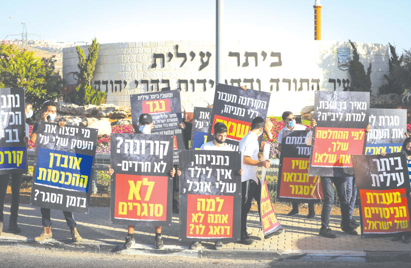 BETAR ILLIT residents protest Wednesday at the entrance to the city against a week-long lockdown due to the high numbers of people newly infected with the coronavirus. (photo credit: NATI SHOHAT/FLASH90)