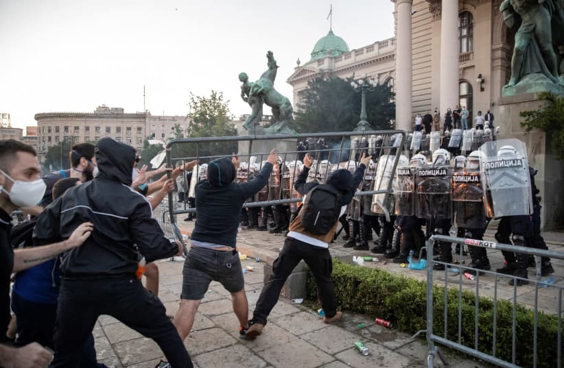 Demonstrators clash with police officers during an anti-government rally, amid the spread of the coronavirus disease (COVID-19), in front of the parliament building in Belgrade, Serbia, July 8, 2020 (photo credit: REUTERS/MARKO DJURICA)
