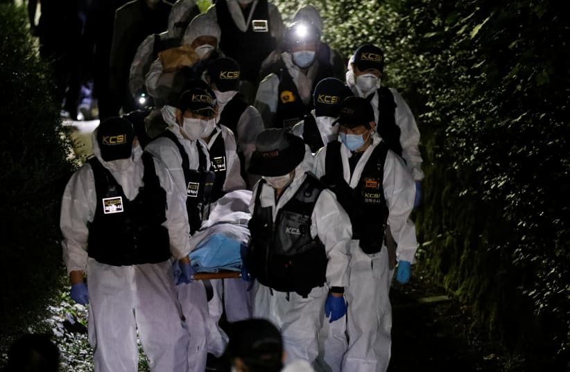 Police officers carry the body of Seoul Mayor Park Won-soon, which was found during a search operation in Seoul, South Korea, July 10, 2020. (photo credit: KIM HONG-JI/ REUTERS)