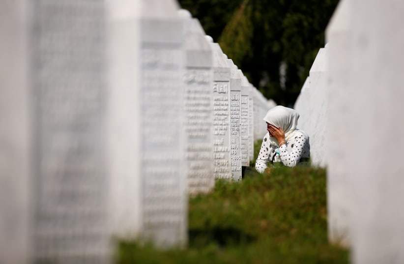 A woman cries at a graveyard, ahead of a mass funeral in Potocari near Srebrenica, Bosnia and Herzegovina July 11, 2020. Bosnia marks the 25th anniversary of the massacre of more than 8,000 Bosnian Muslim men and boys, with many relatives unable to attend due to the coronavirus disease (COVID-19) ou (photo credit: REUTERS/DADO RUVIC)