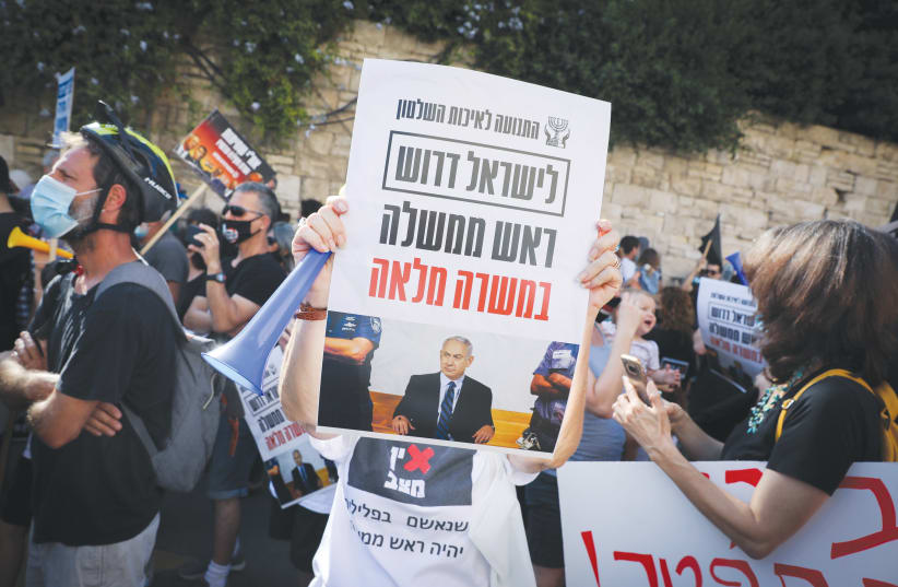 ‘ISRAEL NEEDS a full-time prime minister’ says a protester’s sign outside Prime Minister Benjamin Netanyahu’s residence in Jerusalem on Friday. (photo credit: OLIVIER FITOUSSI/FLASH90)