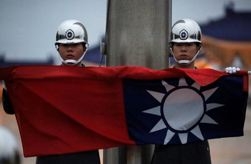 Honor guards perform Taiwan national flag lowering ceremony at Liberty Square in Taipei, as the spread of the coronavirus disease (COVID-19) continues, in Taipei, Taiwan, April 1, 2020. (photo credit: REUTERS)