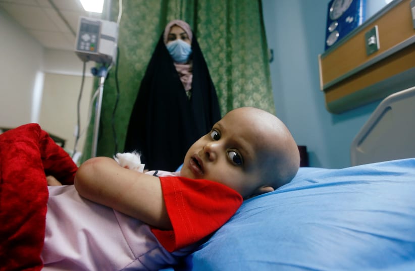 A child who suffers from cancer lies on a bed at the Children's Hospital for Cancer Diseases, amid the spread of the coronavirus disease (COVID-19), in Basra, Iraq July 9, 2020. Picture taken July 9, 2020. (photo credit: ESSAM AL-SUDANI/ REUTERS)