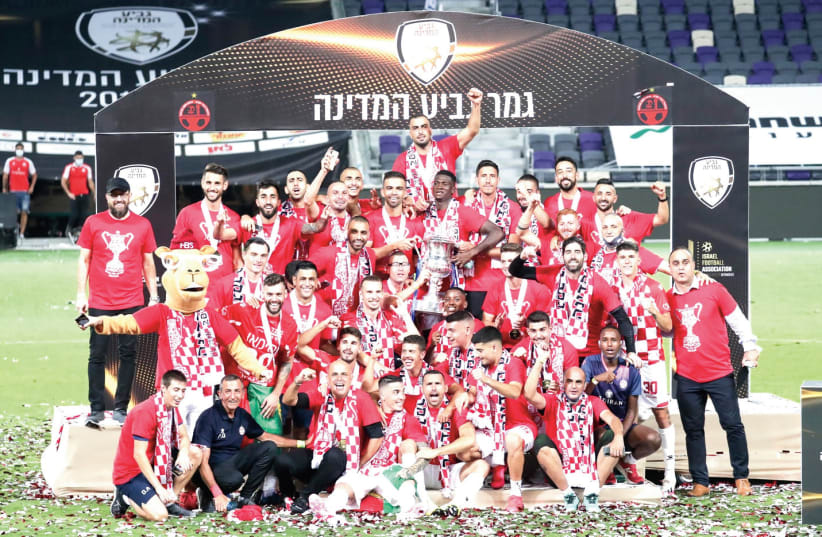 HAPOEL BEERSHEBA players celebrate with the State Cup trophy on the pitch at Bloomfield Stadium on Monday night after beating Maccabi Petah Tikva 2-0 in the final (photo credit: DANNY MARON)