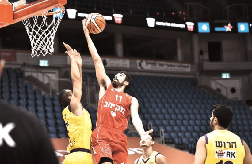HAPOEL JERUSALEM’S Bar Timor goes to the basket during the Reds’ 102-67 home victory over Hapoel Holon in both teams’ final regular-season contest (photo credit: DOV HALICKMAN PHOTOGRAPHY)