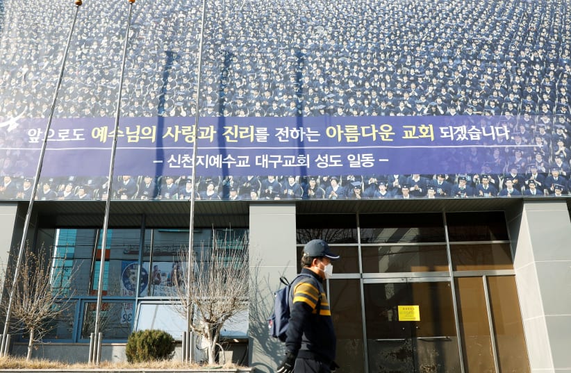 A man wearing a mask walks past a branch of the Shincheonji Church of Jesus the Temple of the Tabernacle of the Testimony, amid rise in confirmed cases of the novel coronavirus disease COVID-19 in Daegu (photo credit: REUTERS)