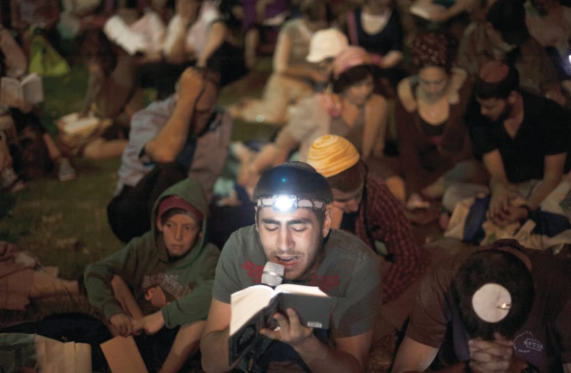 READING MEGILLAT Eicha in Jerusalem’s Independence Park on a previous Tisha Be’Av eve (photo credit: RAFI LETZER/FLASH90)