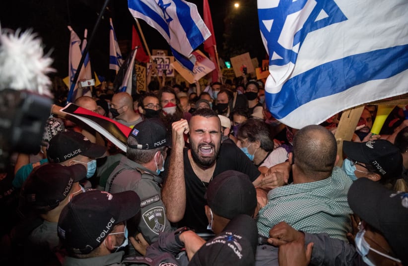 Israeli police officers scuffle with demonstrators during a protest against Israeli prime minister Benjamin Netanyahu outside Prime Minister official residence in Jerusalem on July 14, 2020 (photo credit: YONATAN SINDEL/FLASH90)