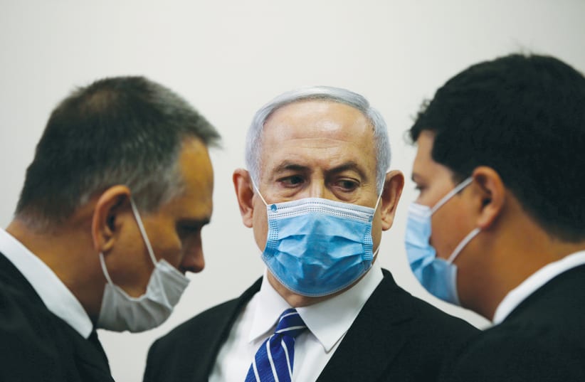 PRIME MINISTER Benjamin Netanyahu with members of his legal team at the beginning of his corruption trial at the Jerusalem District Court in May. (photo credit: RONEN ZVULUN/REUTERS)