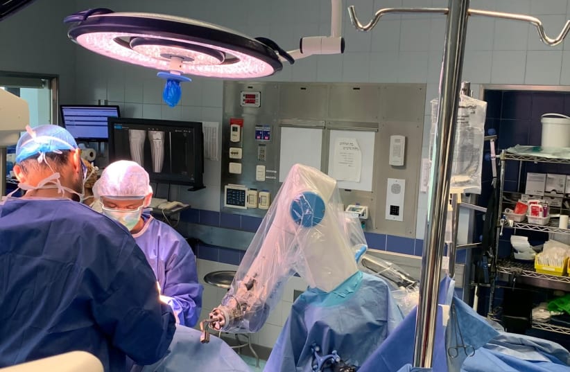Surgeons doing knee surgery at Hadassah hospital's Mount Scopus campus use the ROSA robot, made possible with a grant from USAID's Office of American Schools and Hospitals Abroad. (photo credit: GURION RIVKIN)