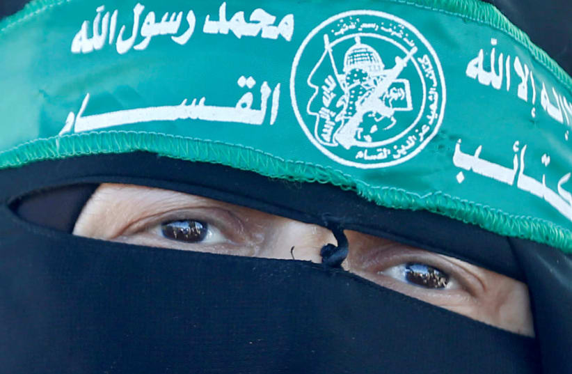 A Palestinian woman wearing the headband of Hamas' armed wing takes part in a protest against Israel's plan to annex parts of the Israeli-occupied West Bank, near Israeli Erez crossing in the northern Gaza Strip July 9, 2020 (photo credit: REUTERS/MOHAMMED SALEM)