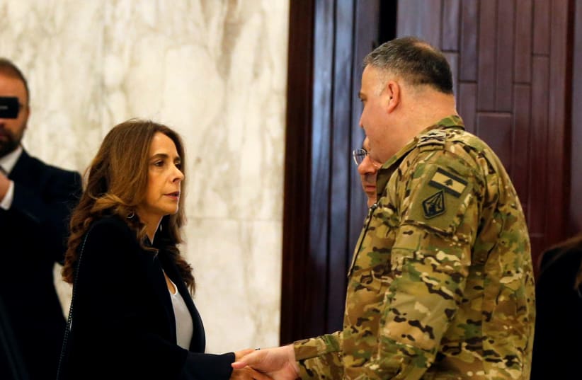 Lebanese Deputy Prime Minister and Defense Minister Zeina Akar shakes hands with a military personnel as she arrives to attend the cabinet meeting at the presidential palace in Baabda (photo credit: REUTERS/MOHAMED AZAKIR)
