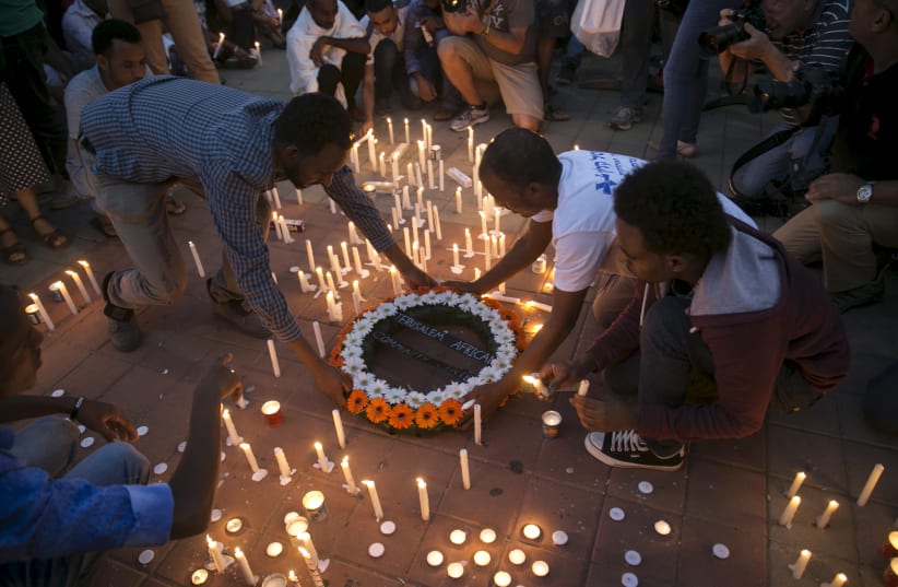 Fellow community members attend a memorial ceremony for Habtom Zarhum, an Eritrean migrant who was mistaken for a gunman at a shooting attack earlier in the week, in Tel Aviv, Israel October 21, 2015 (photo credit: BAZ RATNER/REUTERS)