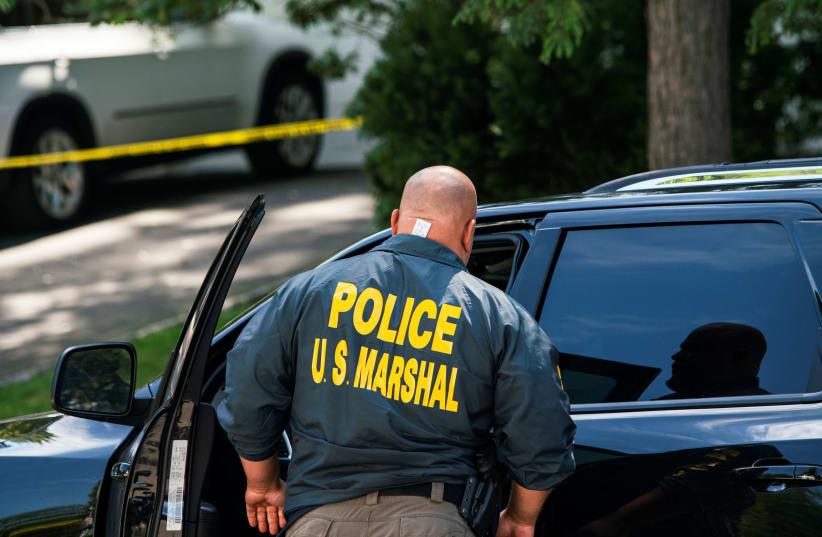 A law enforcement official is seen outside the home of federal judge Esther Salas, where her son was shot and killed and her defense attorney husband was critically injured, in North Brunswick, New Jersey, U.S. July 20, 2020.  (photo credit: REUTERS/EDUARDO MUNOZ)