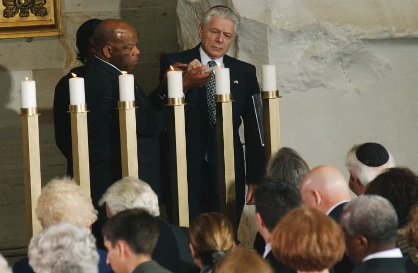 John Lewis, D-Ga., and Norbert Bikales, who was part of the Kindertransport from Berlin to France in July 1939 following the deportation of his parents and brother to Poland, light one of six candles representing the more than six million Jews who were killed during the Holocaust, in a ceremony in t (photo credit: SCOTT J. FERRELL/CONGRESSIONAL QUARTERLY/GETTY IMAGES)