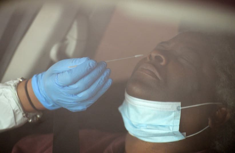 A medical worker administers a test for the coronavirus disease (photo credit: REUTERS)