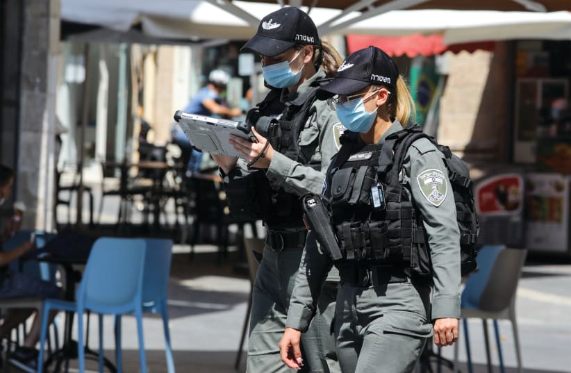Two police officers patrol downtown Jerusalem to ensure that people are wearing masks (photo credit: MARC ISRAEL SELLEM)