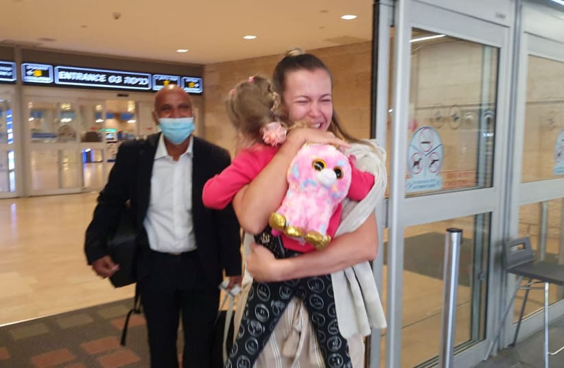 Alona, hugs her three-year old daughter Melaniya Petrushanska, who spent almost a sixth of her life in accidental exile after Israel sealed its borders while she was a broad to stem the spread of the coronavirus disease (COVID-19), upon their reunion at Ben Gurion International Airport near Tel Aviv (photo credit: ISRAIR/HANDOUT VIA REUTERS)