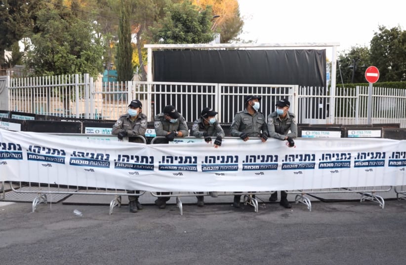 Israel Border Police stand at the ready ahead of protests, behind a line of Likud Party posters (photo credit: MARC ISRAEL SELLEM)