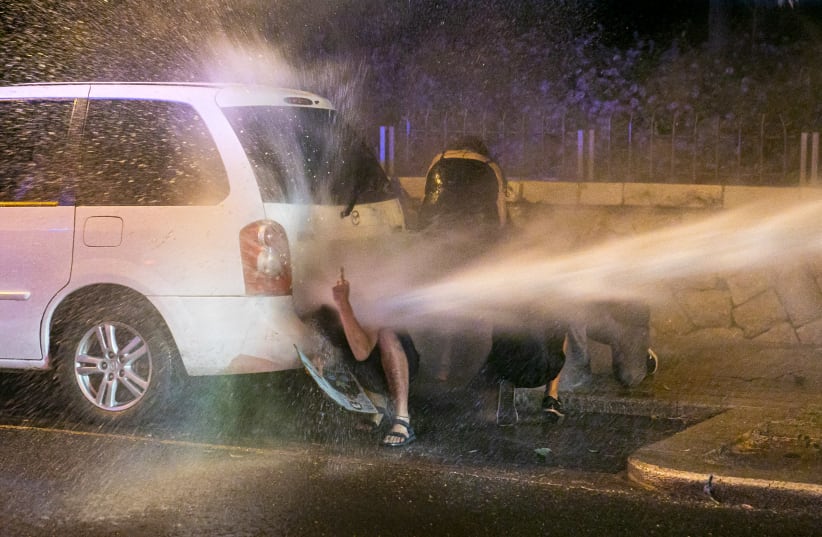 Israeli Police uses water cannon to disperse demonstrators during protest against Prime Minister Benjamin Netanyahu  (photo credit: OLIVIER FITOUSSI/FLASH90)