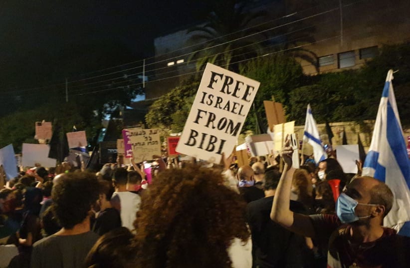 Protester holds a sign that says "Free Israel from Bibi" outside of the Prime Minister's Residence during a demonstration on July 25, 2020 (photo credit: TAMAR BEERI)