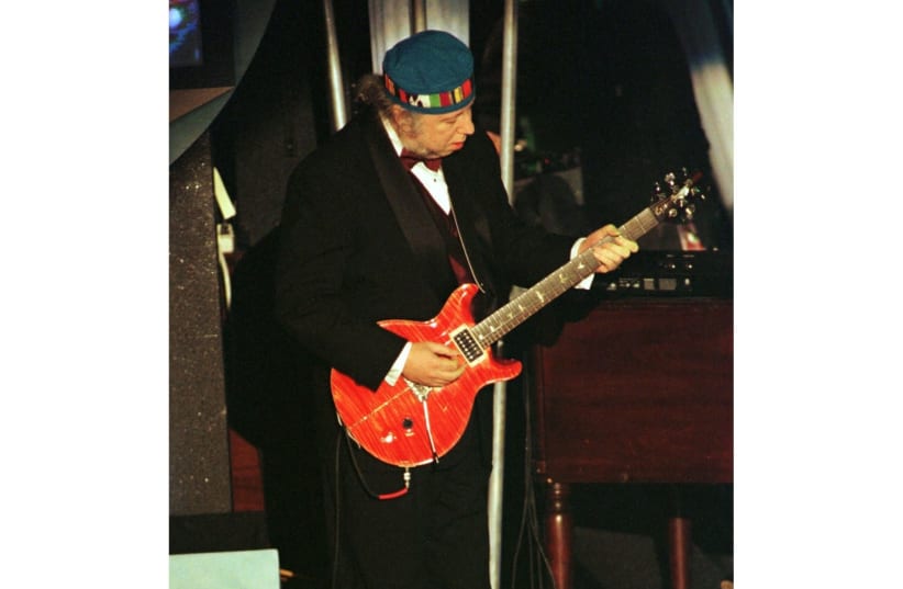 FILE PHOTO: Rarely seen guitarist Peter Green, of the original Fleetwood Mac band, performs his original song "Black Magic Woman" with Carlos Santana (not seen) following Santana's induction into the Rock and Roll Hall of Fame at the Rock and Roll Hall of Fame Foundation's Thirteenth Annual Inductio (photo credit: REUTERS FILE PHOTOS)