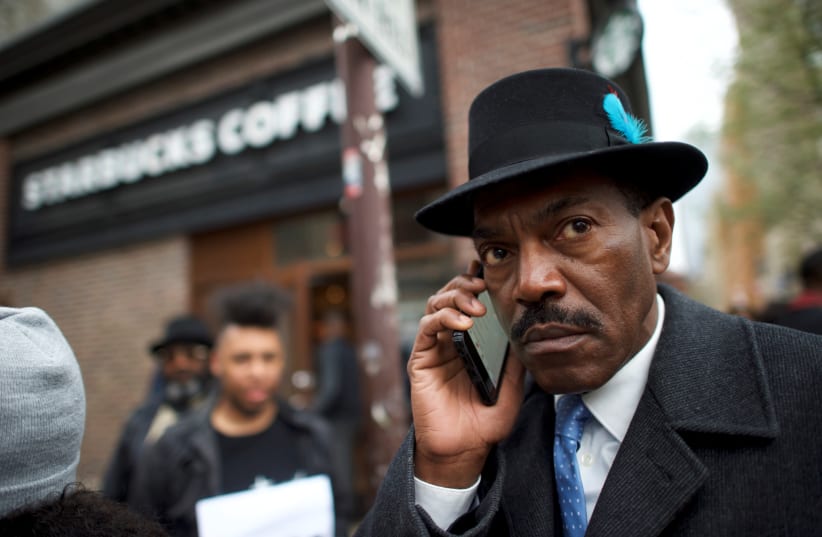 Minister Rodney Muhammad, 65, speaks on the phone after attending a protest with fellow Interfaith clergy leaders outside the Center City Starbucks, where two black men were arrested, in Philadelphia, Pennsylvania US April 16, 2018. (photo credit: MARK MAKELA / REUTERS)