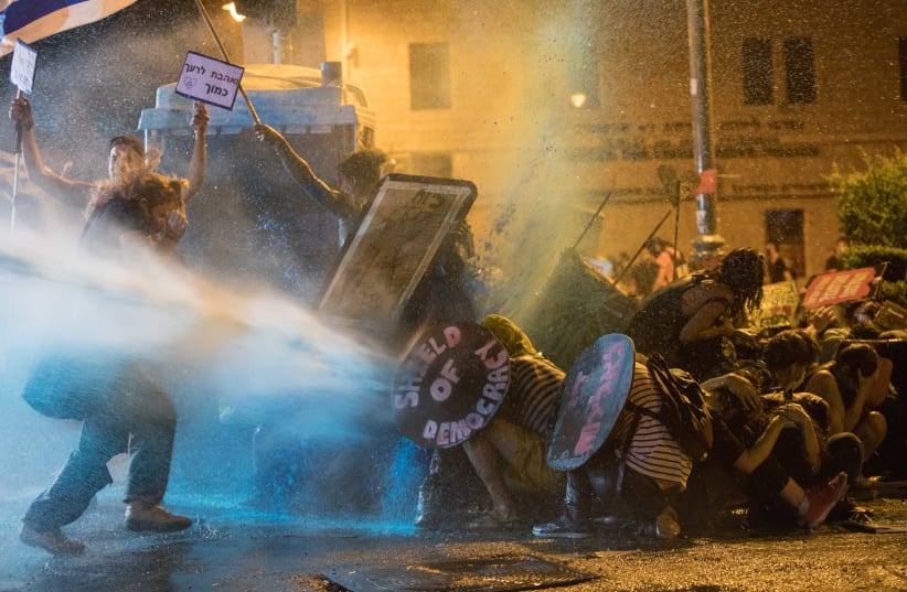 Israeli Police use a water cannon to disperse demonstrators during a protest against Prime Minister Benjamin Netanyahu outside the Prime Minister's Residence, Jerusalem, July 25, 2020 (photo credit: NOAM REVKIN FENTON/FLASH90)