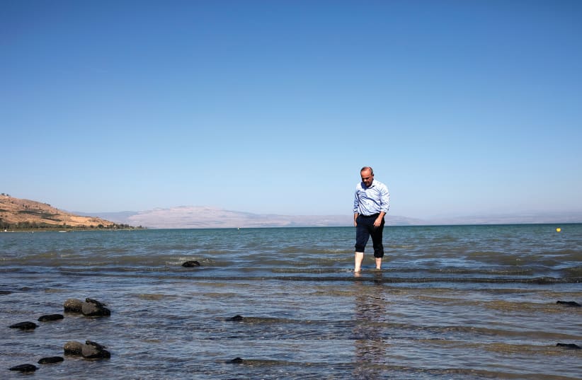 ENERGY MINISTER Yuval Steinitz walks in the Sea of Galilee in 2018. (photo credit: RONEN ZVULUN/REUTERS)