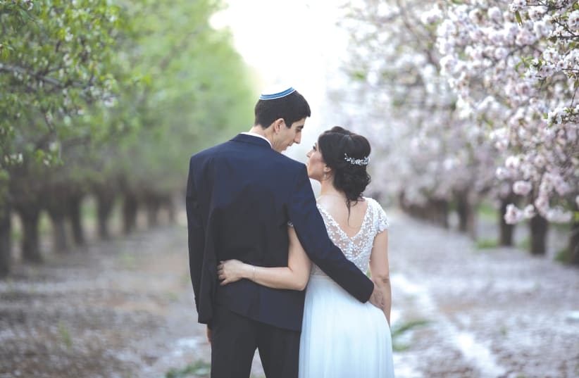 A NEW bride and groom visit a blossoming almond grove in Latrun on their wedding day in 2019. (photo credit: HADAS PARUSH/FLASH90)