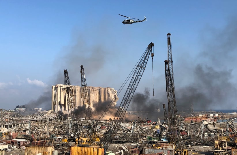 A Lebanese army helicopter flies over the site of Tuesday's blast in Beirut's port area (photo credit: REUTERS/ISSAM ABDALLAH)