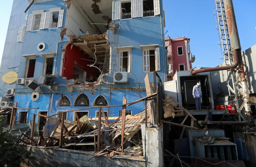 A man inspects the damage following Tuesday's blast in Beirut's port area (photo credit: MOHAMED AZAKIR / REUTERS)