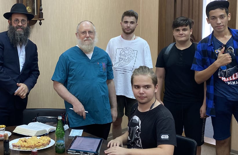 Rabbi Chaim Danzinger, left, introduces Dr. Yeshaya Shafit, second from left, to Jews awaiting circumcision at the synagogue of Rostov-on-Don in Russia, July 27, 2020 (photo credit: COURTESY OF THE JEWISH COMMUNITY OF ROSTOV/JTA)