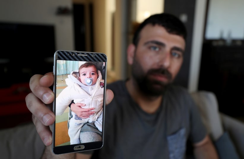 Ahmed Yaghi, the father of Palestinian infant Omar, who died of illness, shows his picture on his mobile phone in the central Gaza Strip June 24, 2020. Picture taken June 24, 2020. (photo credit: MOHAMMED SALEM/REUTERS)