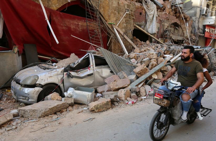 A man rides on a motorbike near rubble from damaged buildings following Tuesday's blast in Beirut's port area, Lebanon August 6, 2020. (photo credit: REUTERS)
