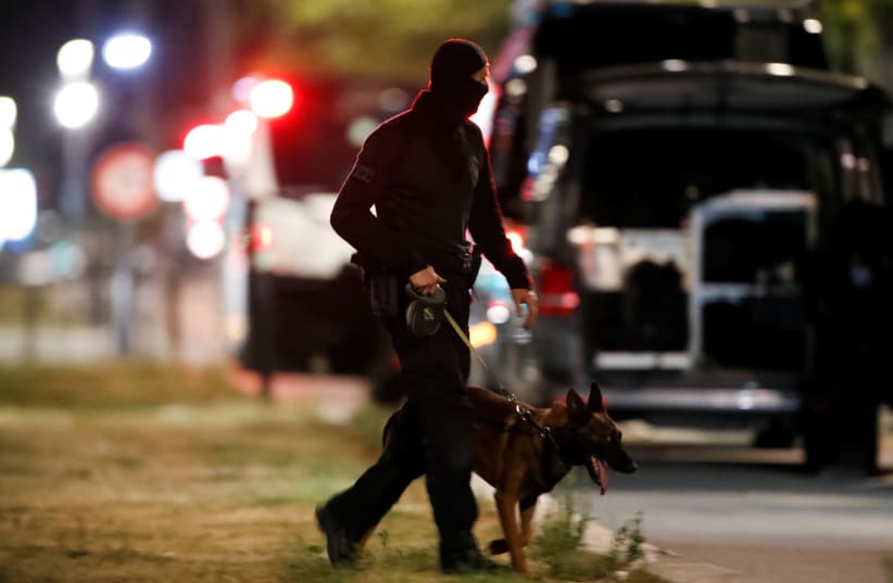 A police officer with a dog secures the area near the bank where an armed man held hostages, in Le Havre, France, August 6, 2020 (photo credit: REUTERS)