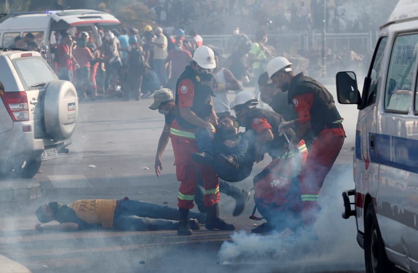 Rescuers assist demonstrators during a protest, following Tuesday's blast, in Beirut, Lebanon August 8, 2020 (photo credit: REUTERS/THAIER AL-SUDANI)