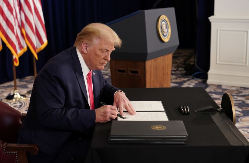 US President Donald Trump signs executive orders for economic relief at his golf resort in Bedminster, New Jersey, US, August 8, 2020. (photo credit: JOSHUA ROBERTS / REUTERS)